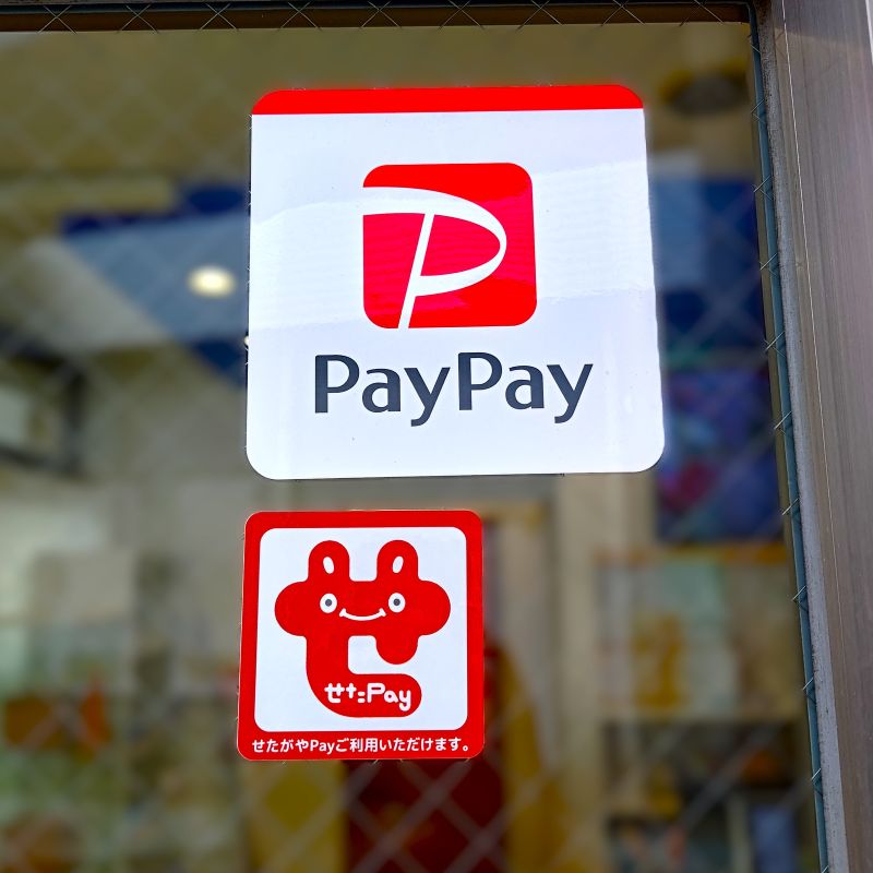 店の入り口に貼り付けた、PayPayとせたがやPayのステッカー。